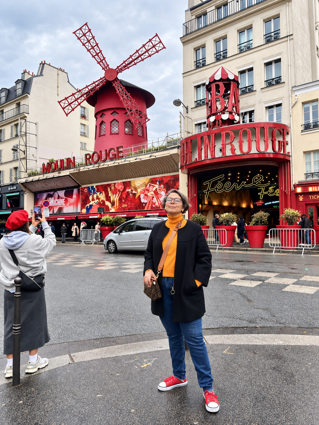 Viajante diante do Moulin Rouge no bairro de Montmartre em Paris